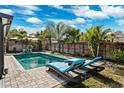 Inviting backyard pool area with brick pavers, sun loungers, and lush tropical landscaping at 1035 County Road 90, Palm Harbor, FL 34684