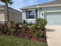 Close-up of the beautifully landscaped front yard with a variety of plants and mulch at 10646 Pepper Dawn Cir, San Antonio, FL 33576