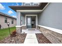 Charming front entry with decorative stone accents and an open door at 12704 Vander Way, New Port Richey, FL 34654