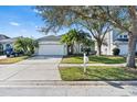 Charming single-Gathering home with a well-manicured lawn, mature trees, and a two-car garage at 1645 Fennsbury Ct, Wesley Chapel, FL 33544