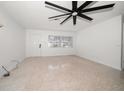 Bright living room featuring neutral walls, ceiling fan, window, and terrazzo flooring at 1672 Cambridge Dr, Clearwater, FL 33756