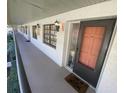 Inviting front entry with a peach-colored door, decorative mat, and outdoor lighting at 2070 Lakeview Dr # 206, Clearwater, FL 33763