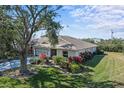 Single-story home showcasing a well-manicured lawn and lush landscaping at 2517 Lynx Rd # 20, Sun City Center, FL 33573