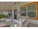 Cozy front porch featuring a swing, comfortable seating, and a welcoming view through the front door at 321 W Wilder Ave, Tampa, FL 33603