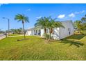 Side view of a white single story home showcasing landscaping and a palm tree at 4043 93Rd N Ter, Pinellas Park, FL 33782