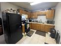 Traditional-style kitchen with black appliances, wood cabinets, and tile floors at 4208 N 31St St, Tampa, FL 33610