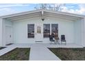 Inviting front porch with seating area, stylish front door, and neutral exterior paint at 4414 W Paris St, Tampa, FL 33614