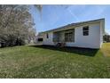 Well-manicured lawn, a covered patio with wooden stairs, and a freshly painted white exterior at 5885 114Th N Ter, Pinellas Park, FL 33782