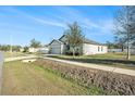 Side view of a gray house with a garage and grassy yard at 725 Garden Oaks Sq, Seffner, FL 33584