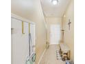 Bright hallway featuring neutral paint, tile flooring, coat closet, and seating for removing footwear at 780 Spring Flowers Trl, Brandon, FL 33511