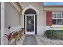 Close-up of a decorative front door with a brick path, shutters, and landscape at 1004 Regal Manor Way, Sun City Center, FL 33573