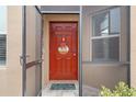 Charming entryway with a red front door, seasonal wreath, and decorative welcome mat at 13351 Crest Lake Dr, Hudson, FL 34669