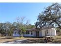 Charming single-story home with picnic table, complemented by mature trees under a bright, sunny sky at 13386 Taylor St, Brooksville, FL 34613