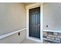 Modern front door with a digital doorbell and stone accents at 16725 Barnwood Pl, Bradenton, FL 34211