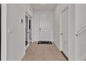 Bright hallway with neutral tile flooring, white walls, and doors leading to various rooms at 16733 Glacier Bay Loop, Wimauma, FL 33598