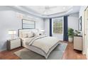 Serene main bedroom with tray ceiling, natural light, and calming decor creates a peaceful retreat at 20033 Heritage Point Dr, Tampa, FL 33647