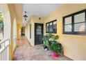 Exterior walkway featuring tile flooring, an arched ceiling, plants, and a black door in a tropical community at 210 22Nd Ne Ave # 14, St Petersburg, FL 33704