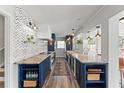 Modern kitchen with blue cabinetry, granite countertops, and chevron backsplash at 2506 Madrid Way S, St Petersburg, FL 33712