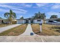 Front view of a renovated single story home with white brick exterior at 2904 Matchlock Dr, Holiday, FL 34690