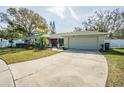 Well-maintained home featuring a long driveway leading to an attached two-car garage at 3704 Thornwood Pl, Tampa, FL 33618