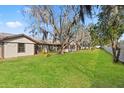 Spacious backyard with mature trees, green grass, and a bright, open feel at 4472 Bayridge Ct, Spring Hill, FL 34606