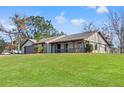 Well-maintained exterior with a lush green lawn, garage, and a charming covered porch at 4472 Bayridge Ct, Spring Hill, FL 34606