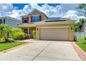 Two-story house with solar panels and a two-car garage at 5365 Shasta Daisy Pl, Land O Lakes, FL 34639