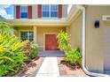 Inviting front entry with red door and brick walkway at 5365 Shasta Daisy Pl, Land O Lakes, FL 34639