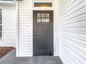 Stylish black front door with glass pane and white siding, welcomes you home at 7800 Willow Brook Ct, Hudson, FL 34667