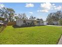 Charming home featuring a well-kept lawn, fresh landscaping, and a vibrant yellow door at 8303 Croton Ave, Tampa, FL 33619