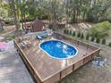 Beautiful in-ground pool surrounded by a wooden deck, perfect for outdoor relaxation and entertaining at 9445 Preston Rd, Brooksville, FL 34601