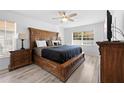 This spacious bedroom features a beautiful carved bed frame, ceiling fan and light wood-look floors at 10340 Ventura Dr, Spring Hill, FL 34608