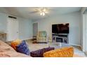 Cozy living room featuring wood-look tile floors, ceiling fan and a flat screen tv at 10800 Us Highway 19 N # 108, Pinellas Park, FL 33782