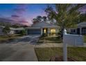 Charming single-story home with screened garage, lush landscaping, and a welcoming front entrance at twilight at 11446 Sinatra, New Port Richey, FL 34654