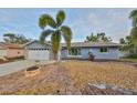 Landscaped front yard with stone accents and a covered entrance, offering curb appeal at 12341 79Th Pl, Seminole, FL 33772