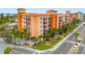 Attractive building featuring multiple balconies, palm trees, and vibrant landscaping at 13235 Gulf Blvd # 306, Madeira Beach, FL 33708