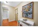 Hallway with decorative artwork, a console table, and tile flooring, leading to the bathroom at 13235 Gulf Blvd # 306, Madeira Beach, FL 33708