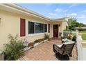 Inviting front porch with brick pavers, comfortable seating, and decorative plants at 1560 Bel Keene Dr, Clearwater, FL 33756