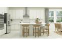 Modern kitchen with island, white cabinets, and stainless steel appliances at 18429 Serene Lake Loop, Lutz, FL 33548