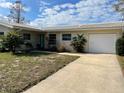 Inviting exterior view of a well-maintained single-story home with an attached garage and nice yard at 2051 High Ridge Dr, Clearwater, FL 33763
