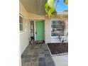 Attractive front entrance with a green door, tiled floor, and decorative security screen at 2051 High Ridge Dr, Clearwater, FL 33763