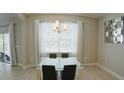 Dining room with a glass table, modern chandelier, and natural light at 3328 W Palmetto St, Tampa, FL 33607