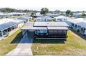 Aerial view of a cozy home featuring a carport, screened in porch, and neat landscaping at 36852 Kimela Ave, Zephyrhills, FL 33542