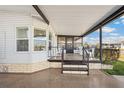 Inviting front porch with seating area, covered entrance and decorative railing at 36852 Kimela Ave, Zephyrhills, FL 33542