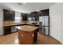 Spacious kitchen with stainless steel appliances, center island, and dark wood cabinets at 4734 Chatterton Way, Riverview, FL 33578