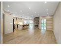 Bright, open-concept living room with a stone fireplace, modern lighting, and hardwood floors at 4777 Duhme Rd # 1A, St Petersburg, FL 33708