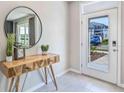 Bright entryway with a wooden console table and a large round mirror at 4978 Eagle Rock Dr, Wimauma, FL 33598