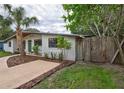 Updated mid-century home with a large yard and wooden fence at 6407 S Clark Ave, Tampa, FL 33616