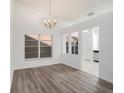 Elegant dining room features hardwood floors, bright windows, and stylish chandelier at 1009 Hardwood Dr, Valrico, FL 33596