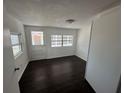 Bright bedroom featuring dark wood-look floors and a door leading to the outside at 1817 Meridel Ave, Tampa, FL 33612